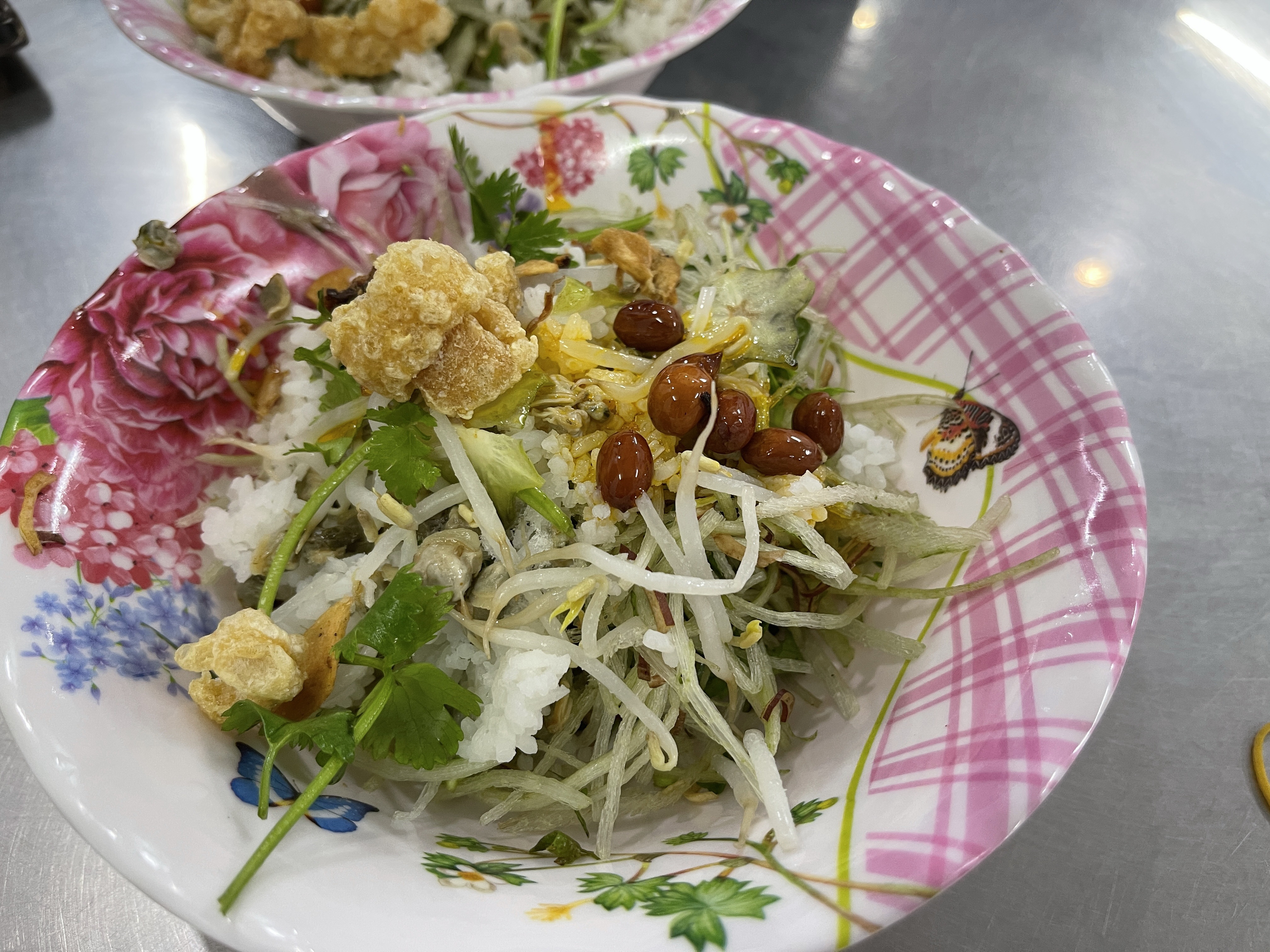 <em>A bowl of </em>cơm hến<em> (rice topped with baby mussels) is served at a stall in the central city of Hue. Photo: </em>Dong Nguyen / Tuoi Tre News