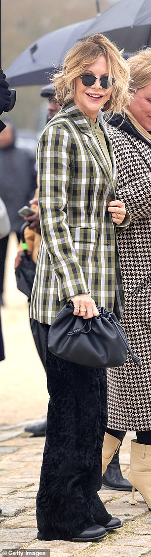 She toted her look with a black leather ruched handbag and opted for also black boots