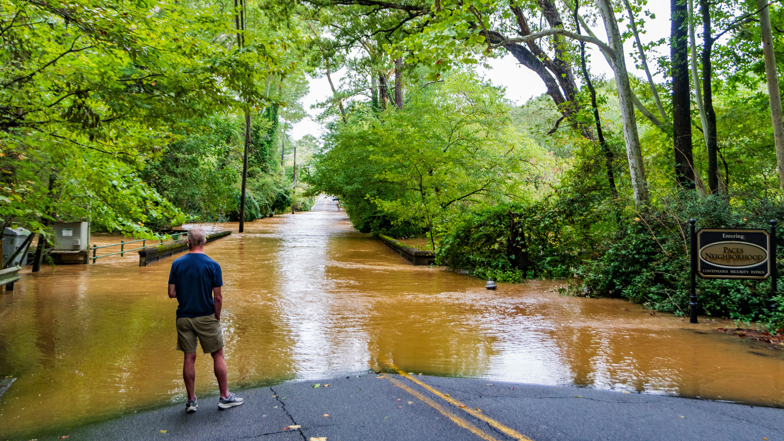 A patron looks at the flooding from Hurricane Helene in the Paces neighborhood, Friday, Sept 27, 2024, in Atlanta. 